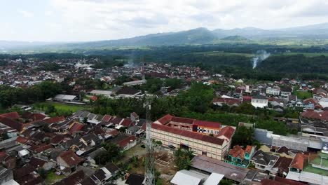 indonesian township with rooftops and smokes, aerial drone view