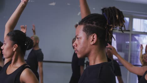 multi-ethnic group of fit male and female modern dancers practicing a dance routine