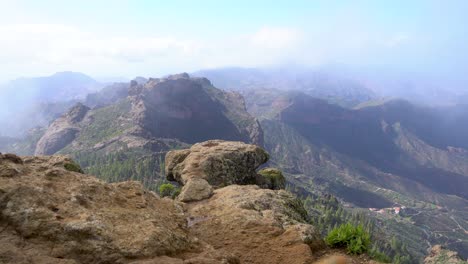 grupo de senderismo ascendiendo al roque nublo duroing una mañana brumosa en la isla de gran canaria, españa