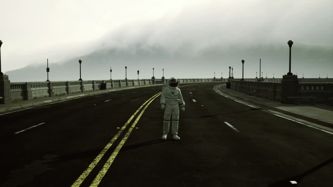 Astronaut standing alone on an empty road with fog covered mountains
