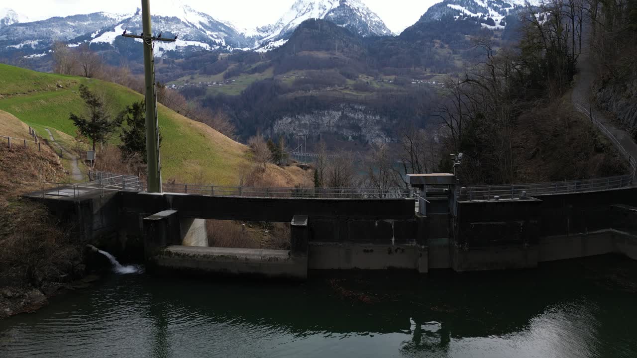 una vista aérea captura la presa de un pequeño embalse ubicado en el pintoresco cañón del arroyo alpino fallenbach, con vistas al lago walen, suiza