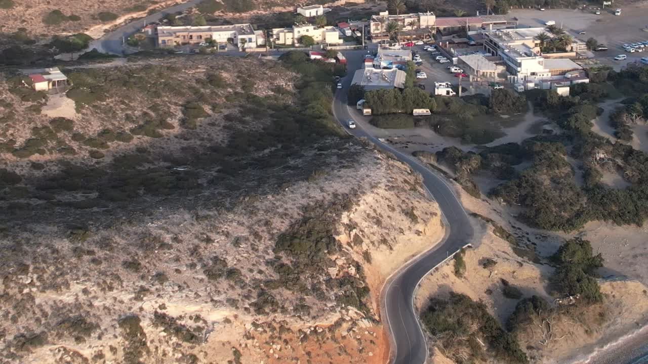View of the winding road and small village in aerial shot of Greece