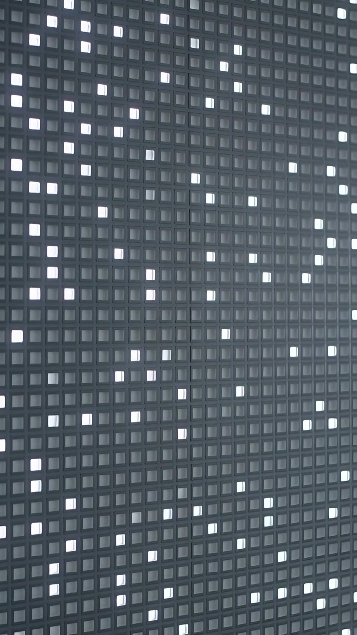Vertical video: Shifting camera revealing bezel and recording LED panel pixels changing inside room