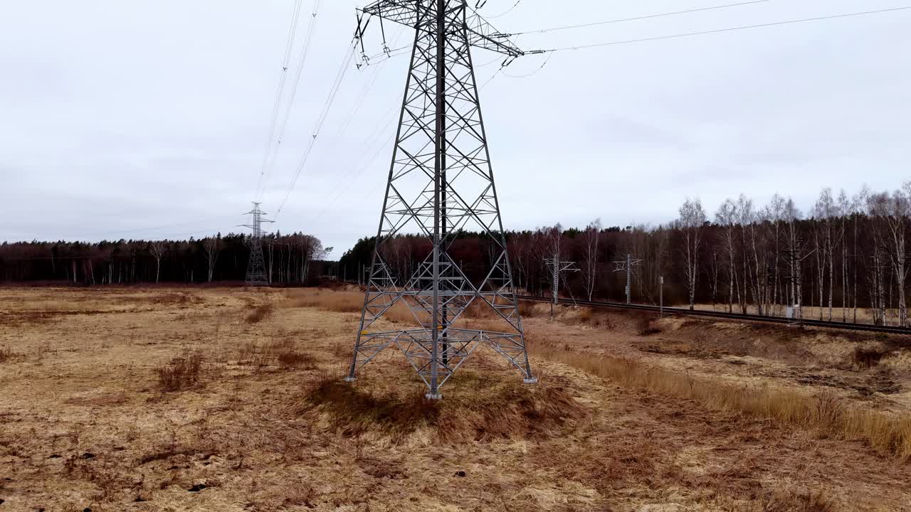 Et højt krafttårn står midt på en mark