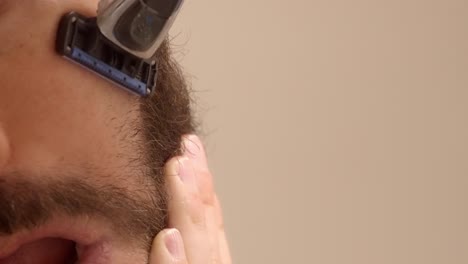 a detailed close-up of a bearded man shaving the hair on his cheek, focusing on grooming and precision.