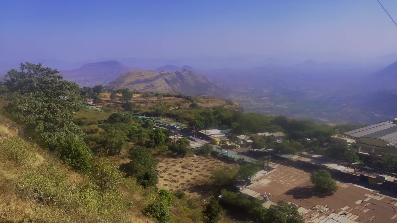 Vista panoramica dalla funicolare Saptashrungi Gad che scende il fianco della collina affacciandosi su valli, montagne e insediamenti vicino a Vani, a Nashik, Maharashtra, India