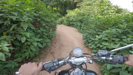 motociclista montando campo a través en un denso callejón verde montando a la montaña en la colina de parasnath en jharkhand, india