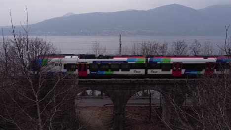 el tren de pasajeros pasa por el ferrocarril cerca del lago maggiore