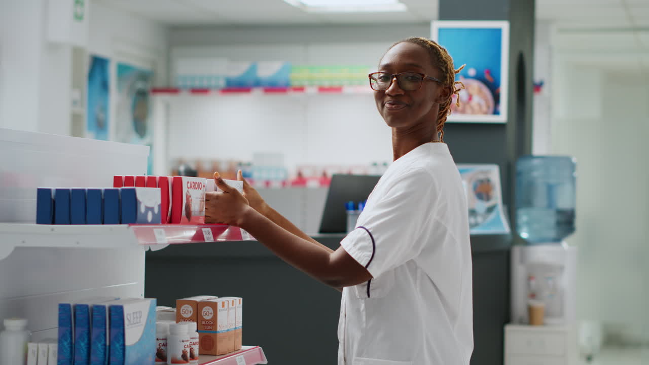 Pharmacien rangeant des médicaments sur les étagères d’une pharmacie