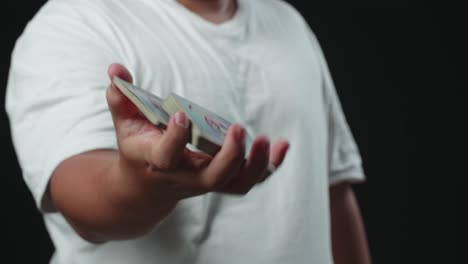 man showing his trick with usual cards, one handed cut