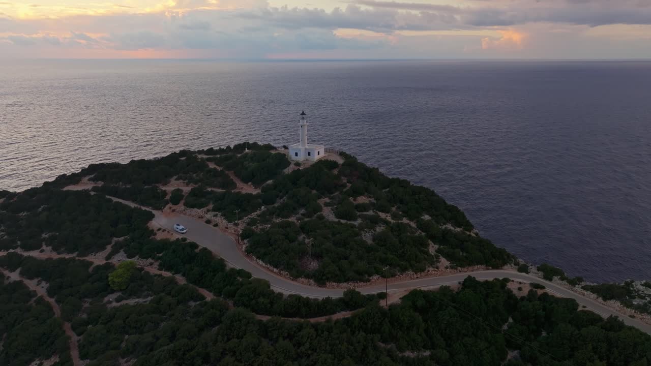 Faro che si erge su una costa frastagliata al tramonto, Lefkada, Grecia