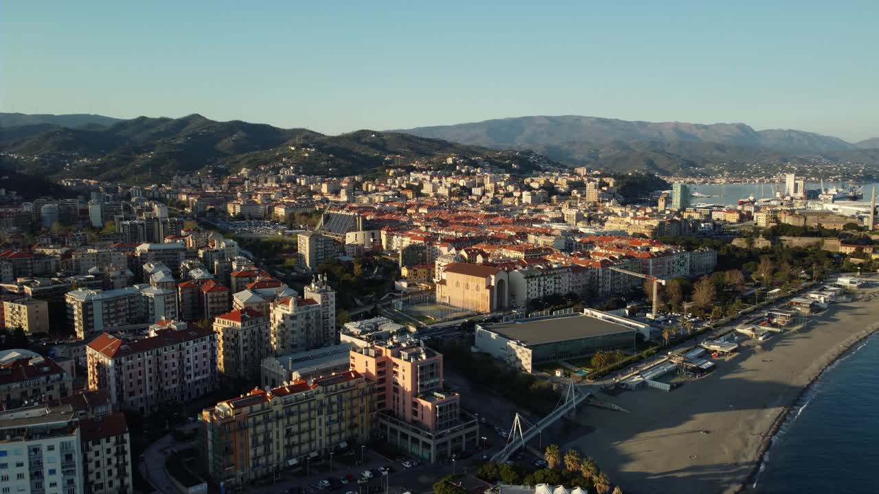 Aerial view of a coastal city with mountains in the background