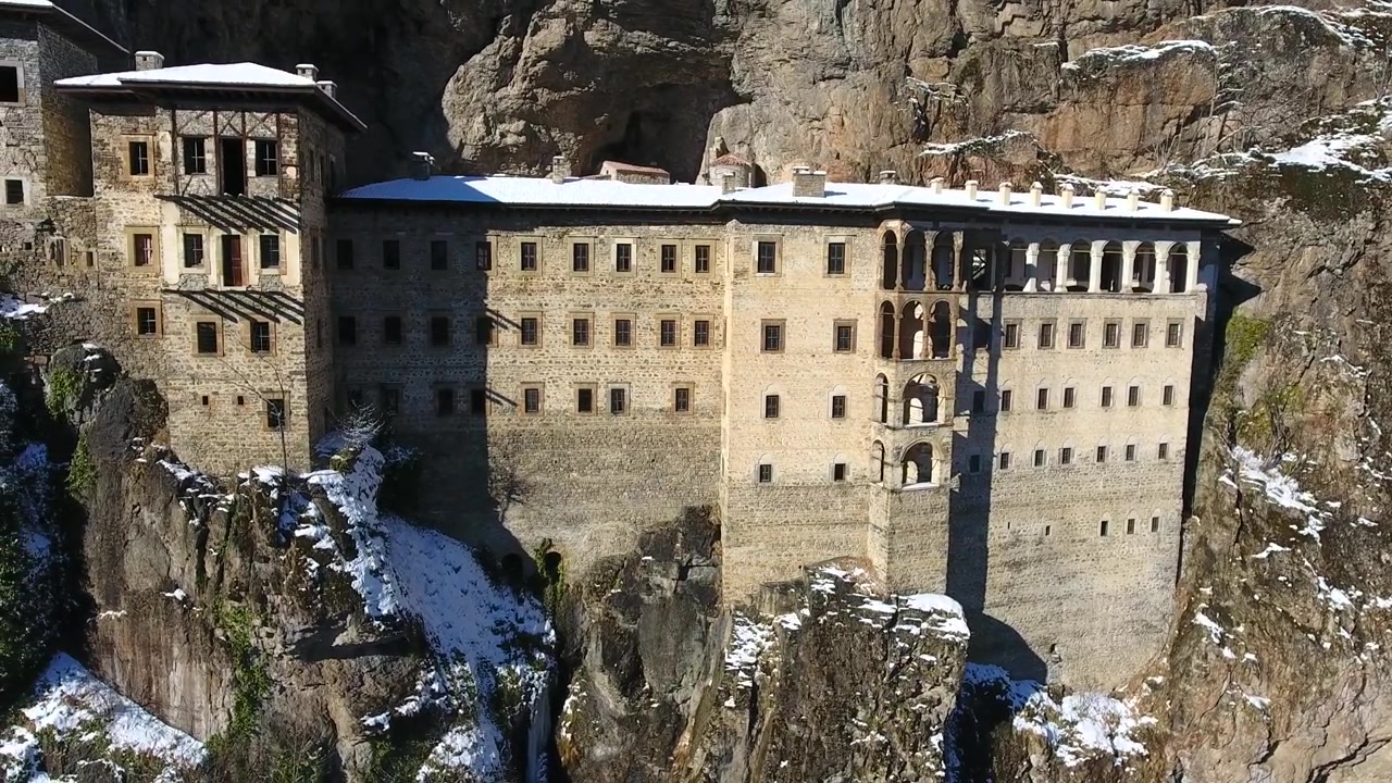Luftfoto af Sumela Kloster bygget ind i en stejl bjergskrænt