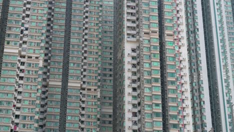 street-level perspective of kowloon’s residential high-rises, china, highlighting urban overcrowding and small living conditions.