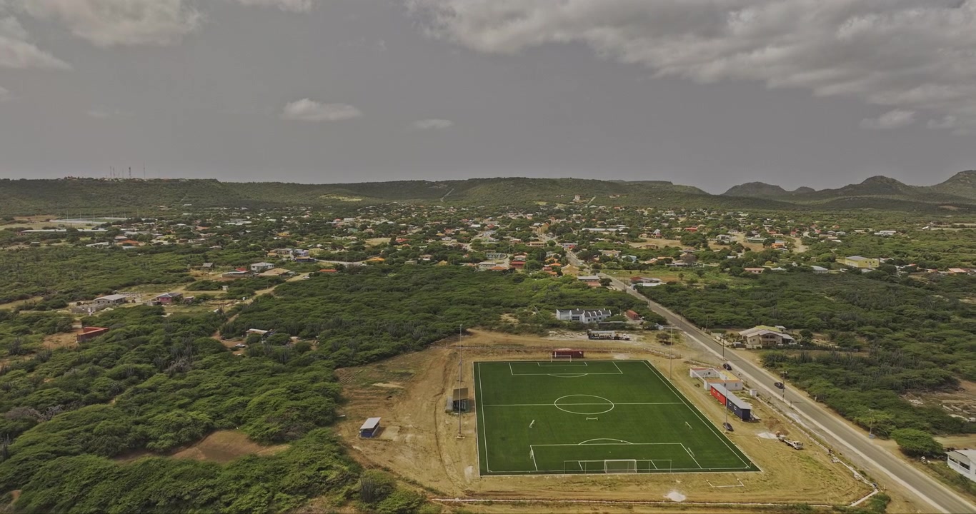 Bonaire, Caribe Neerlandês, sobrevoo aéreo v78 de um campo esportivo em direção a Rincon, revelando ruas residenciais, o centro da cidade e colinas circundantes - Filmado com Mavic 3 Pro Cine - 3 de fevereiro de 2024