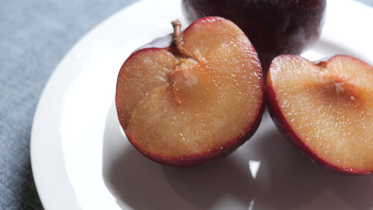 fruta de ciruela roja fresca en rodajas en una mesa de madera foto de alta calidad