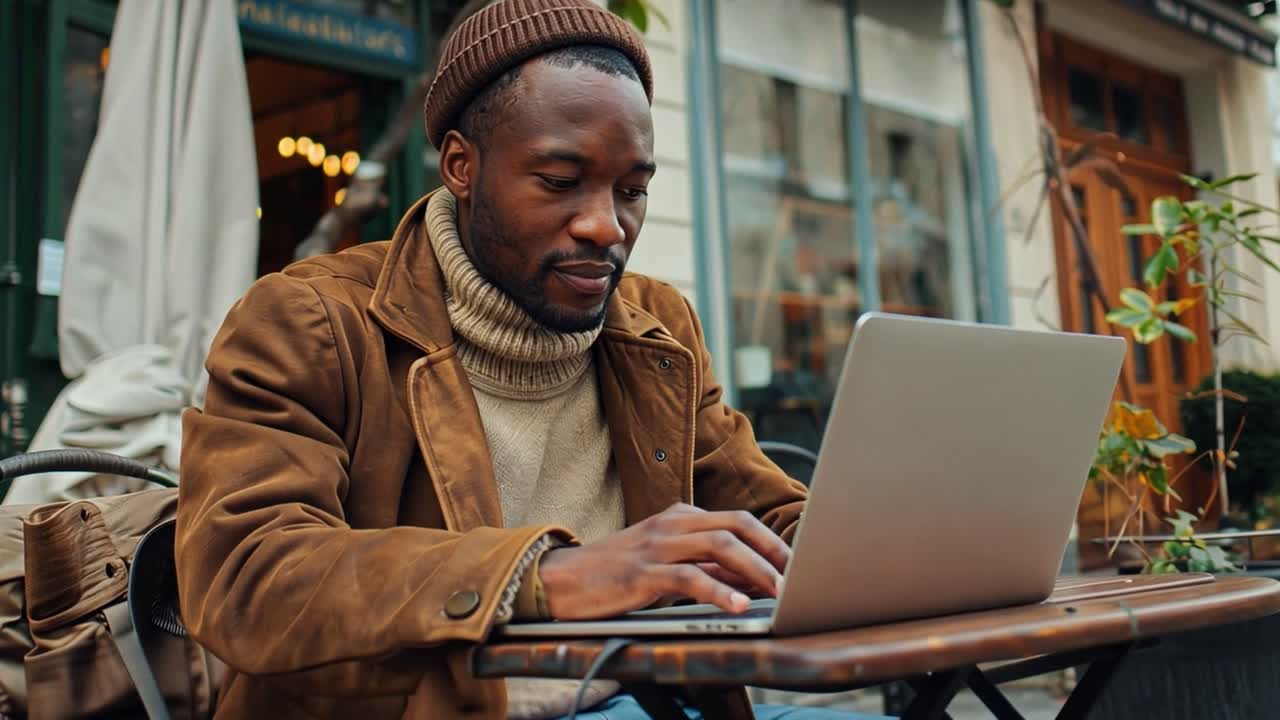Man working on a laptop at an outdoor cafe