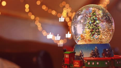 animation of social media thumb up icons over christmas tree in snow globe