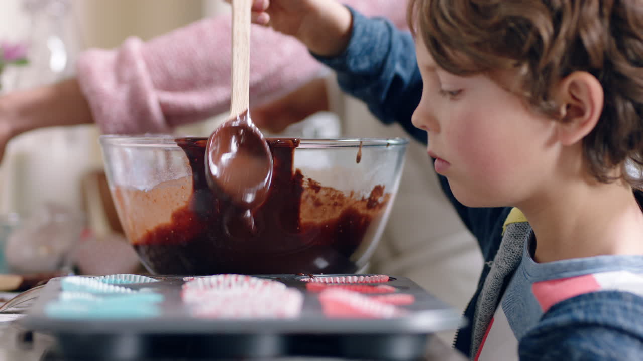 niño feliz ayudando a su madre a hornear en la cocina vertiendo masa en la bandeja de hornear preparando receta de pastel casero en casa