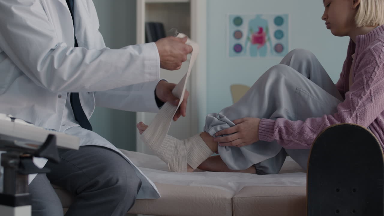 Doctor examining patient's injured ankle