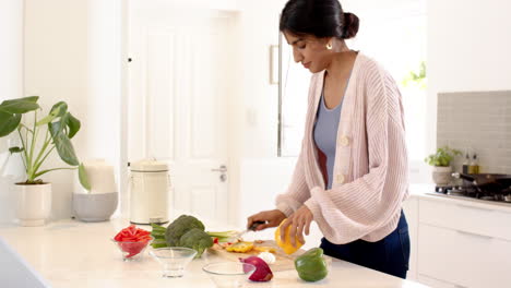 indian woman preparing fresh vegetables in modern kitchen, enjoying cooking at home, copy space