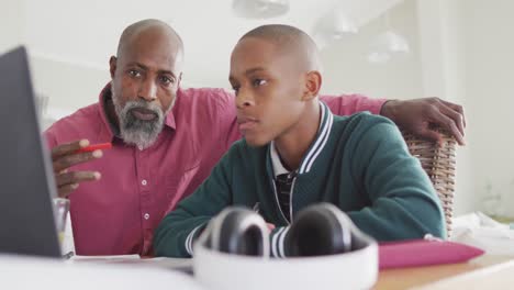 video de un feliz padre y hijo afroamericanos haciendo la tarea juntos