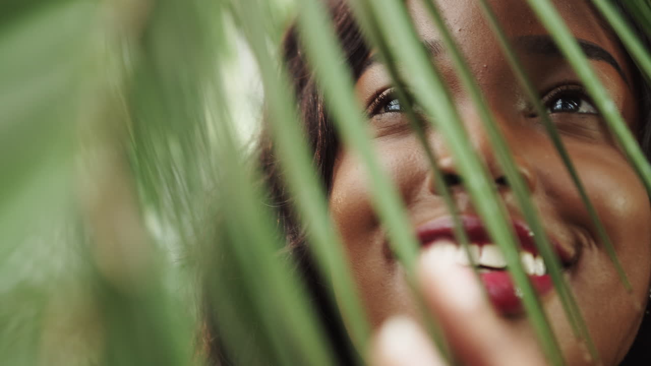 Volto di una bellissima ragazza con foglie verdi di fiori e piante, cosmetici naturali e cura della pelle