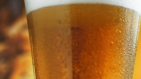 la cerveza se está vertiendo en un vaso angulado. ipa en el grifo. cerveza ligera fría en un vidrio con gotas de agua. cerveza artesanal formando olas de cerca. frescura y espuma. fondo de bar. cerveza artesanal de microbrewery.
