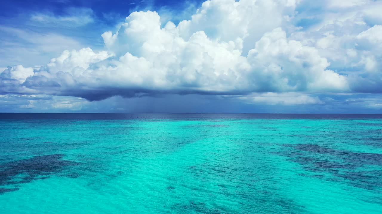 Dramatic sky with heavy low fluffy white clouds above the beautiful Caribbean sea. Endless open ocean motion background