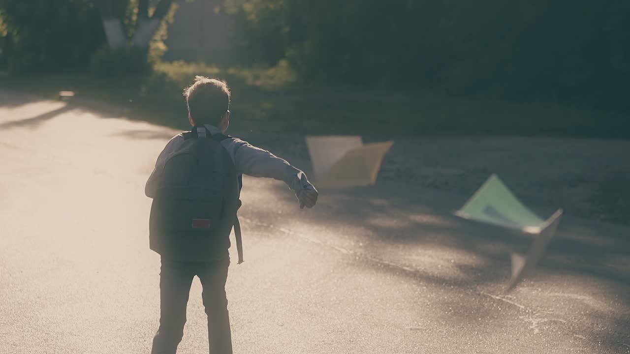 젊은 남자가  ⁇  종이 시트를 던지고 점프하고 학교를 빠져나갑니다.