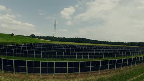 Drone-flying-above-the-agricultural-field-and-photovoltaic-system,-solar-panels-installed-in-rows-between-the-fields,-Styria,-Austria