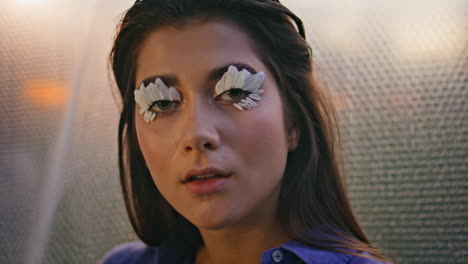 closeup woman eyelashes blossoms at blurred backdrop. makeup with flower petals