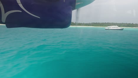 seaplane landing on blue tropical water in maldives near island, window view