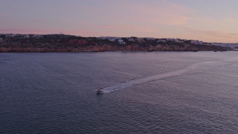 Aerial-tracking-shot-of-speed-fisher-boat-driving-on-ocean-at-Albufeira-Portugal,-aerial