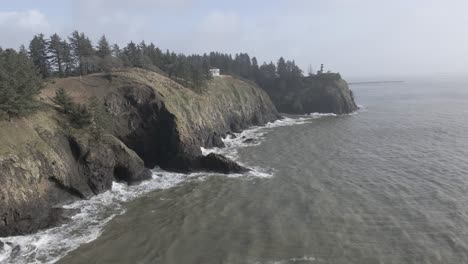 cape disappointment lighthouse sits on a jagged bluff high above the turbulent ocean, aerial trackback