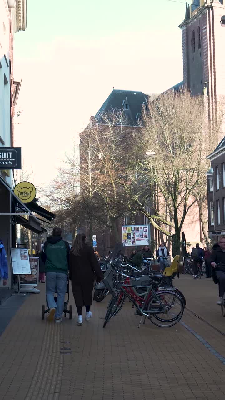Människor som går och cyklar på en europeisk stadsgata.