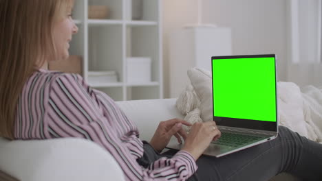 la mujer está hablando en línea usando chat de video en la pantalla verde de la computadora portátil en el portátil para la tecnología chroma key