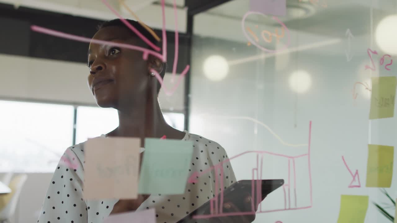 African american businesswoman inventing concept, making notes and smiling