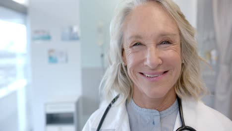 Portrait-of-happy-senior-caucasian-female-doctor-in-hospital-room,-slow-motion