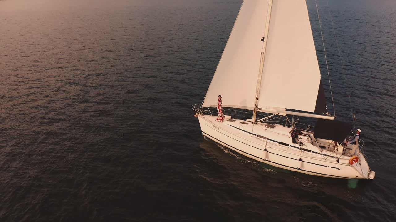 pareja navegando en un yate al atardecer