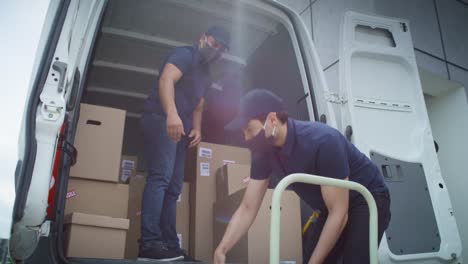 Video of two couriers in protective masks unloading packages
