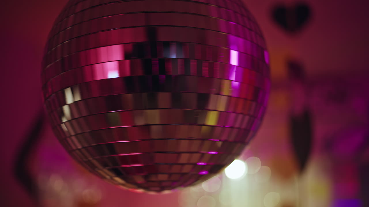 Disco ball rotating nightclub radiating glitter rays closeup. Dance celebration