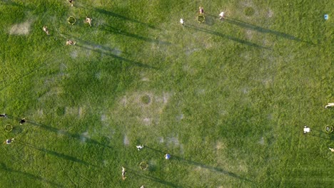 Luftaufnahme-Von-Oben-Nach-Unten-Mit-Zeitrafferaufnahme-Vieler-Menschen,-Die-Auf-Einem-Feld-Spikeball-Spielen