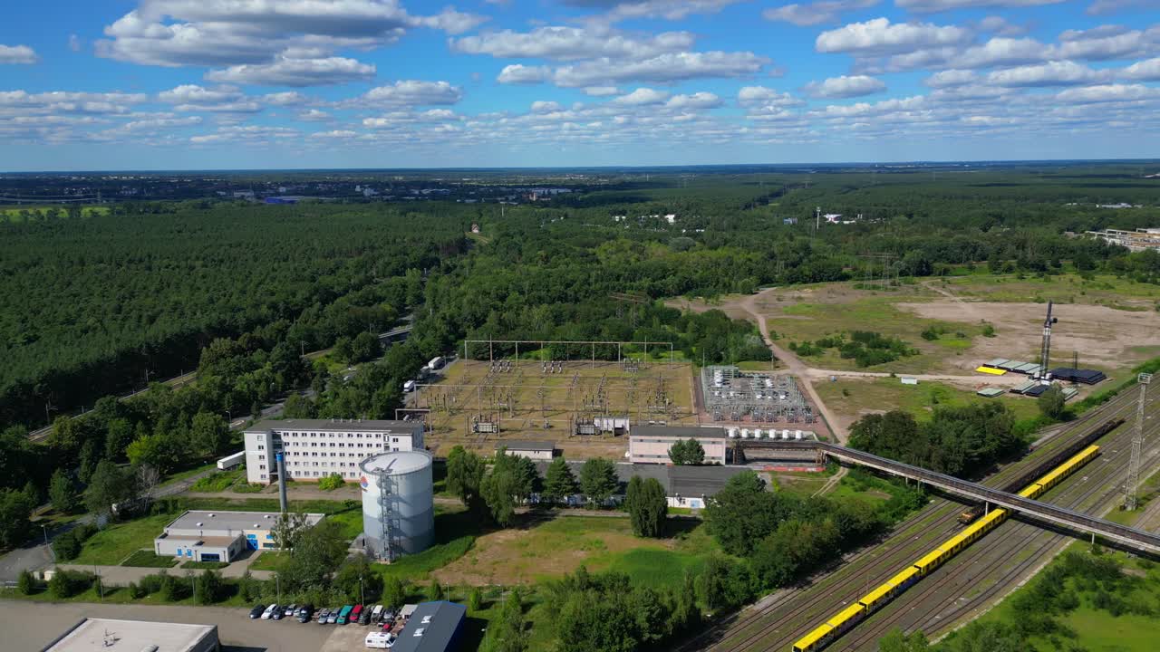 Hennigsdorf substation, distributing electricity and surrounded by a lush green forest in Brandenburg, Germany. Magic aerial view flight panorama overview drone