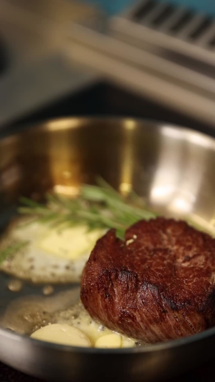 Steak cooking in frying pan with butter and rosemary