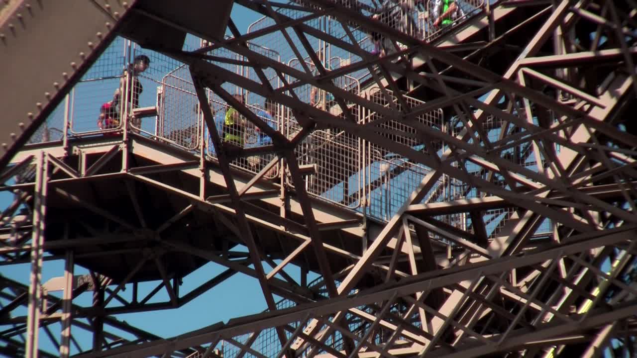 관광객들이 파리의 에펠탑을 걷고 있다