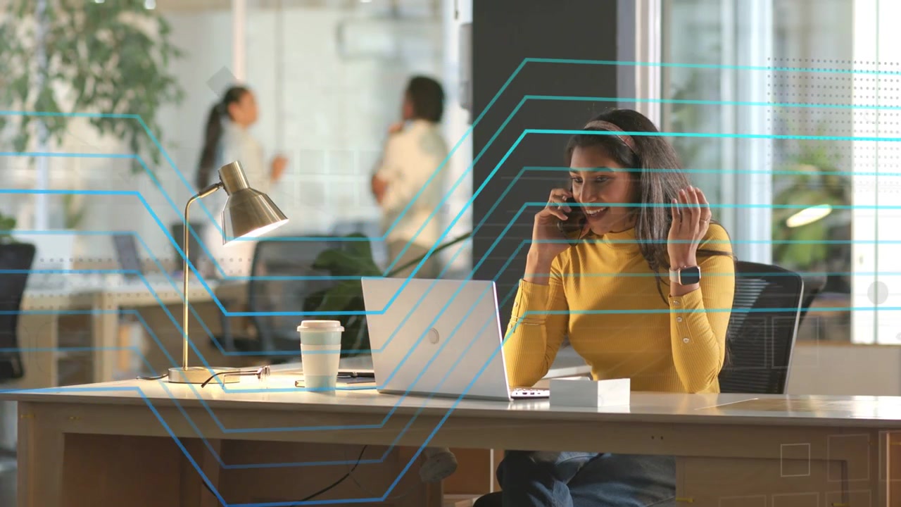 Una donna parla al suo smartphone, dando un'occhiata al laptop e attivando un HUD di sicurezza animato che protegge l'email.