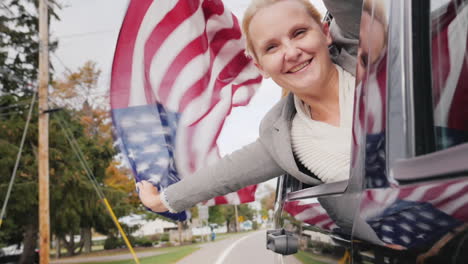 woman with usa flag leans out of car