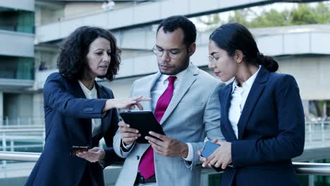 empresarios multiétnicos con dispositivos digitales