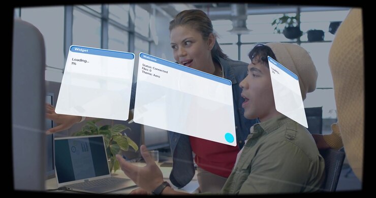Standing woman pointing at laptop, causing faint AR widgets popping, shifting, tech checking status